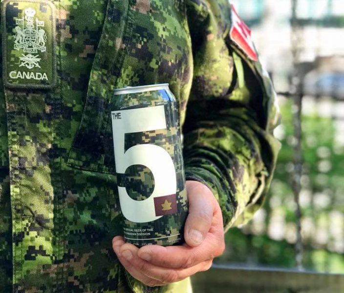Photo of a solider in uniform holding a can of Sober Island Brewing Company's beer