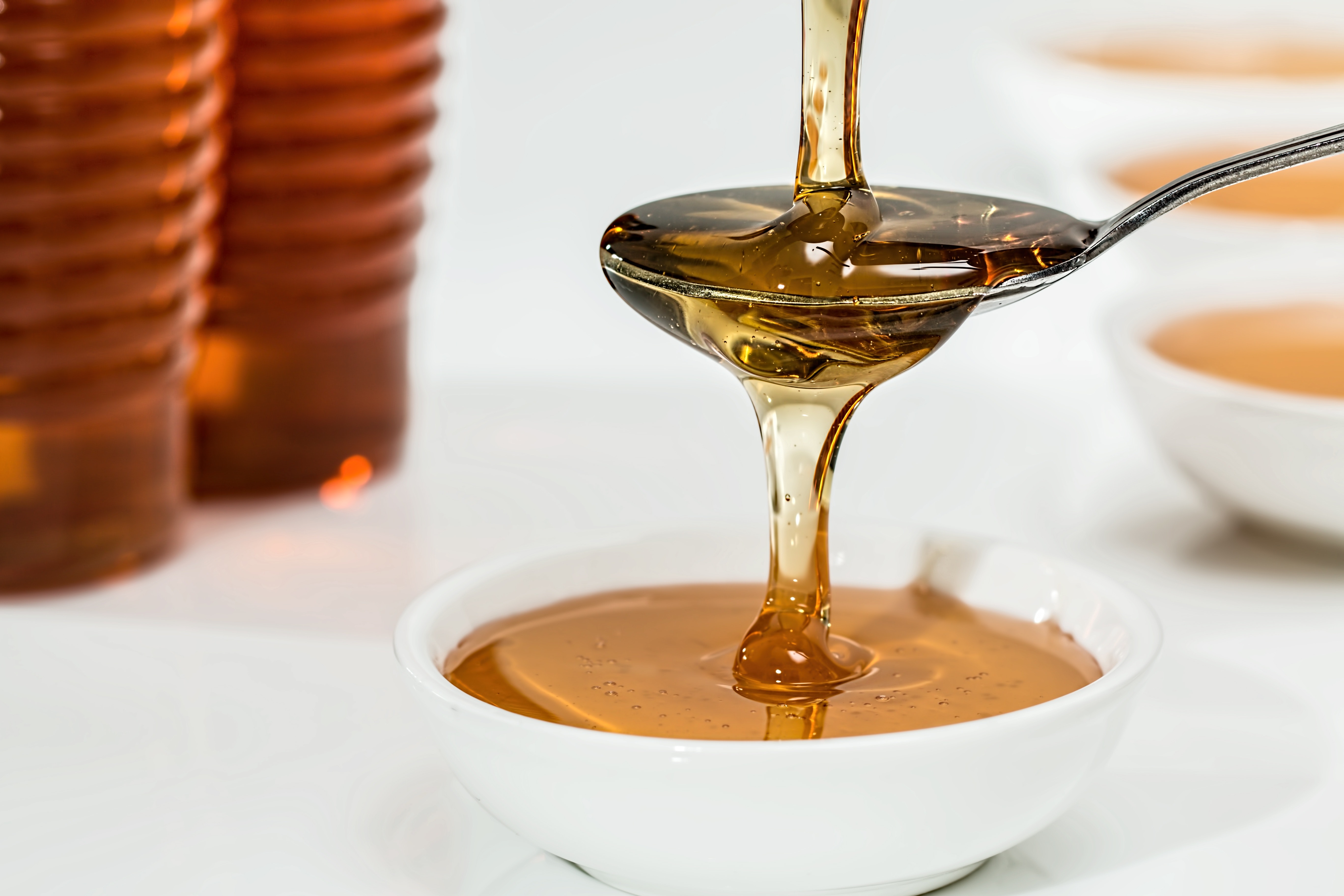 close up of honey being poured onto a spoon