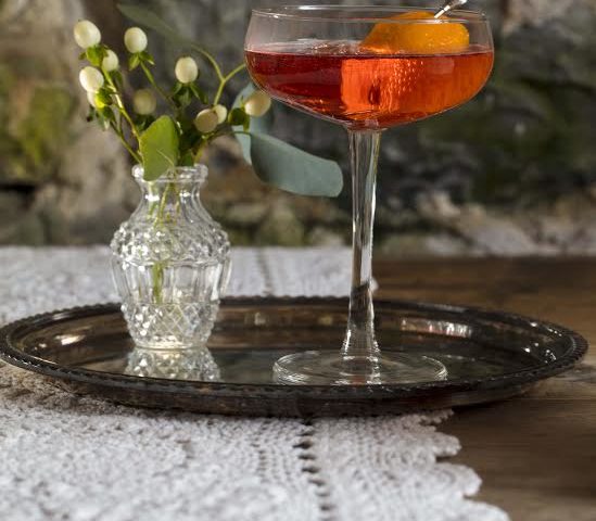 Cocktail in a wide glass sitting on a tray.