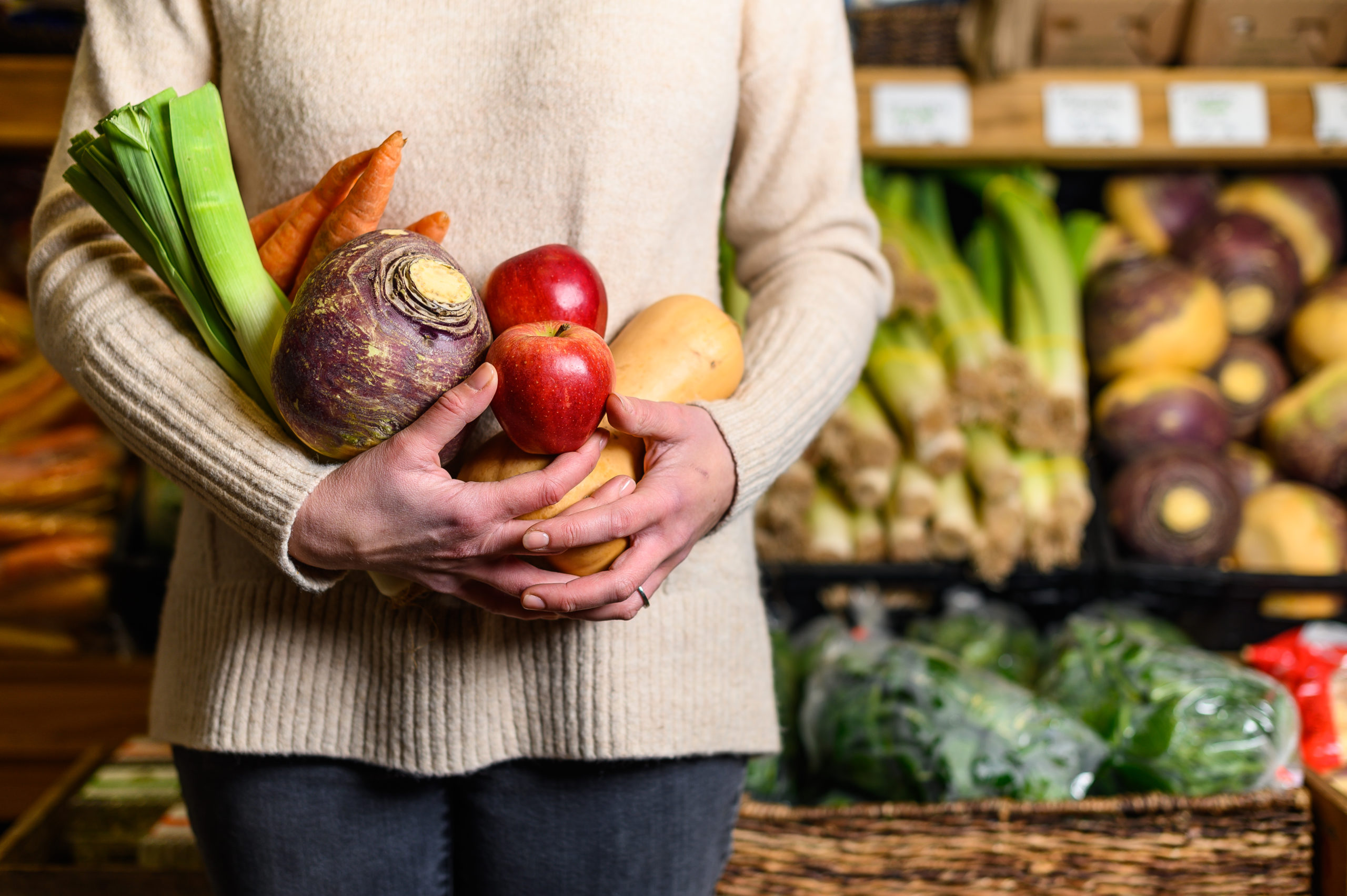 A photo of a woman holding a handful of local produce