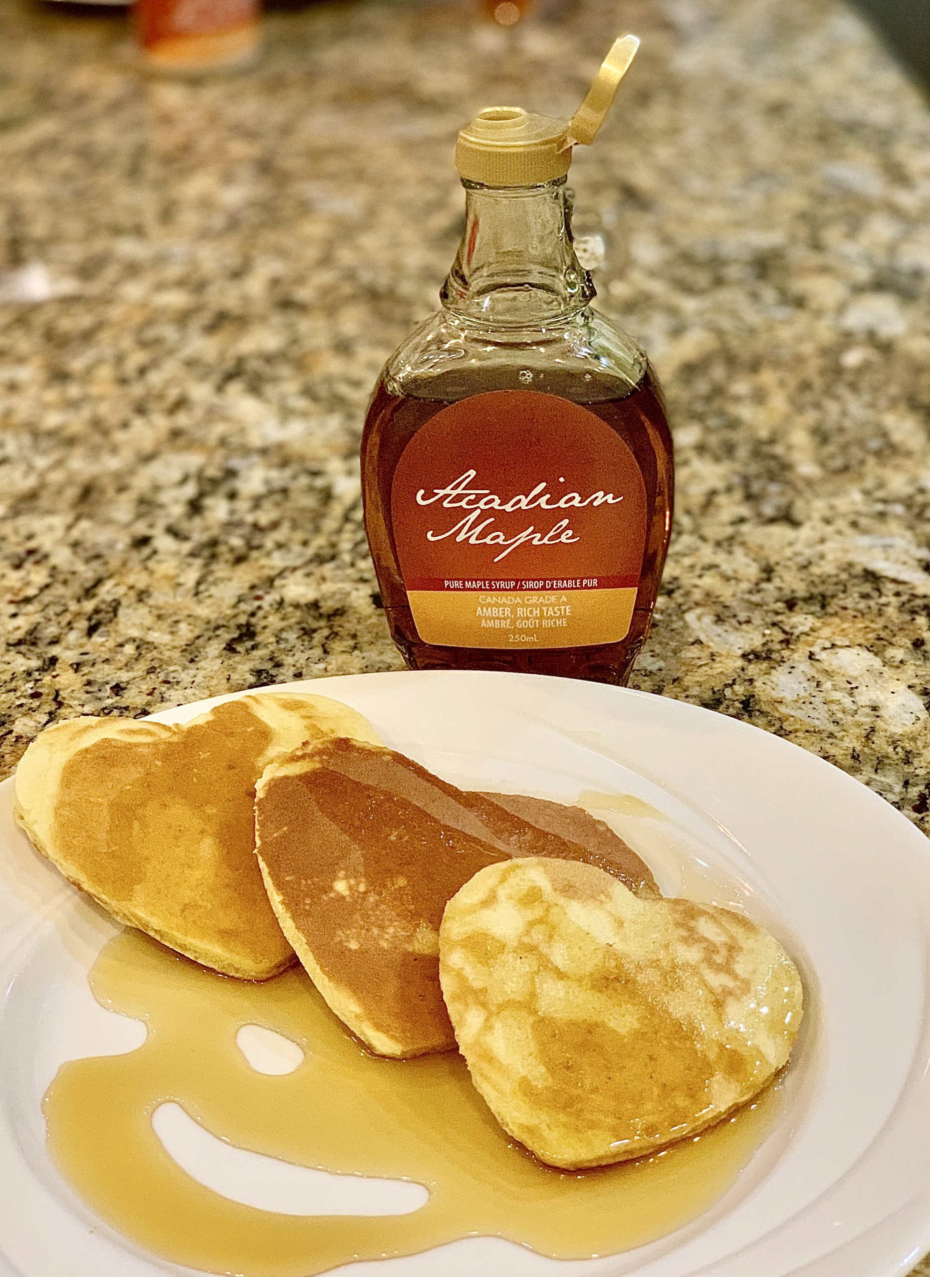 A photo of Acadian maple syrup and heart-shaped pancakes