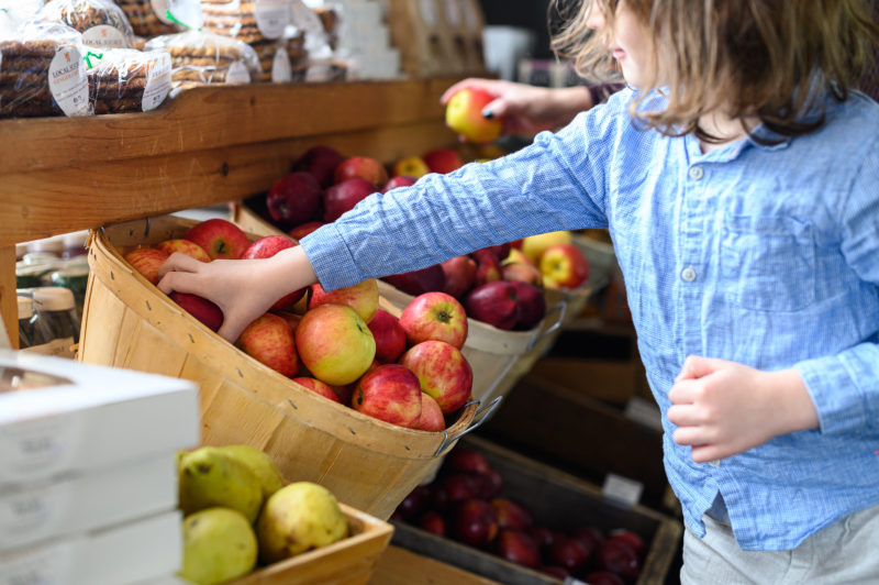 boy picking apples at store