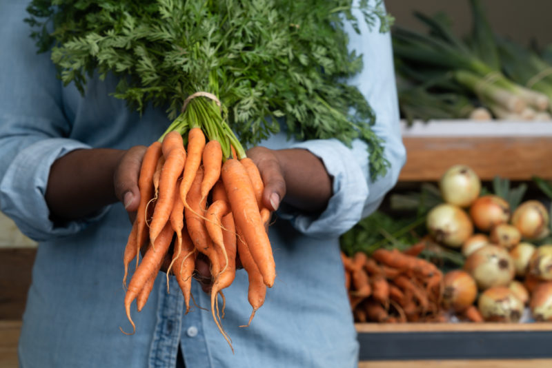 Image of woman holding carrots at Noggins