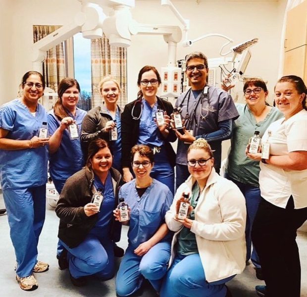 Team of nurses and doctors all holding coldstream sanitizer