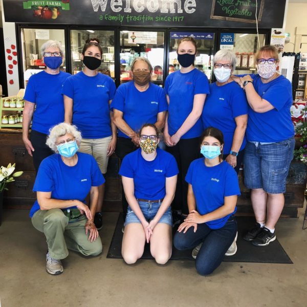 Image of nine staff at Stirling Farm Market in blue t-shirts wearing masks