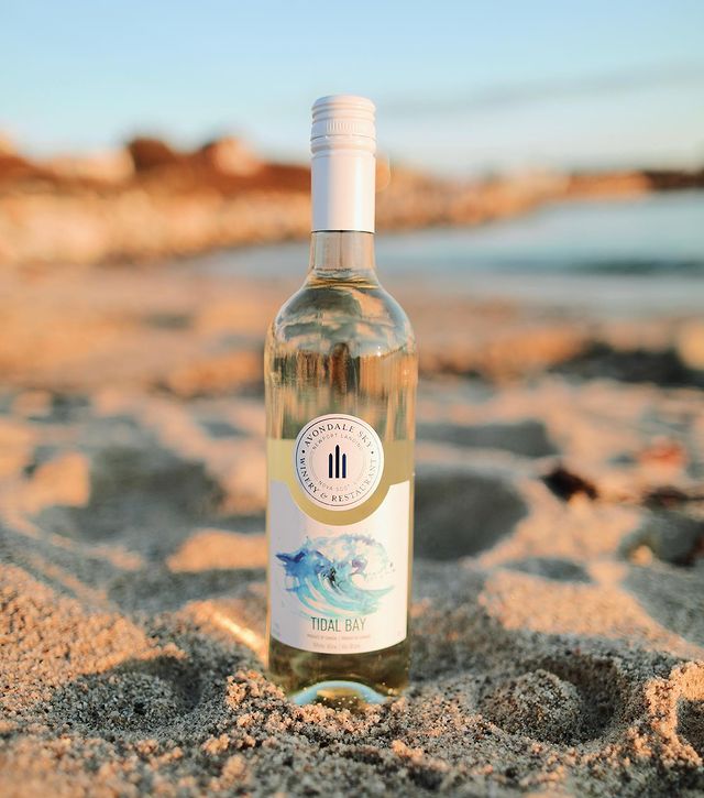 A bottle of Tidal Bay in the sand. 
