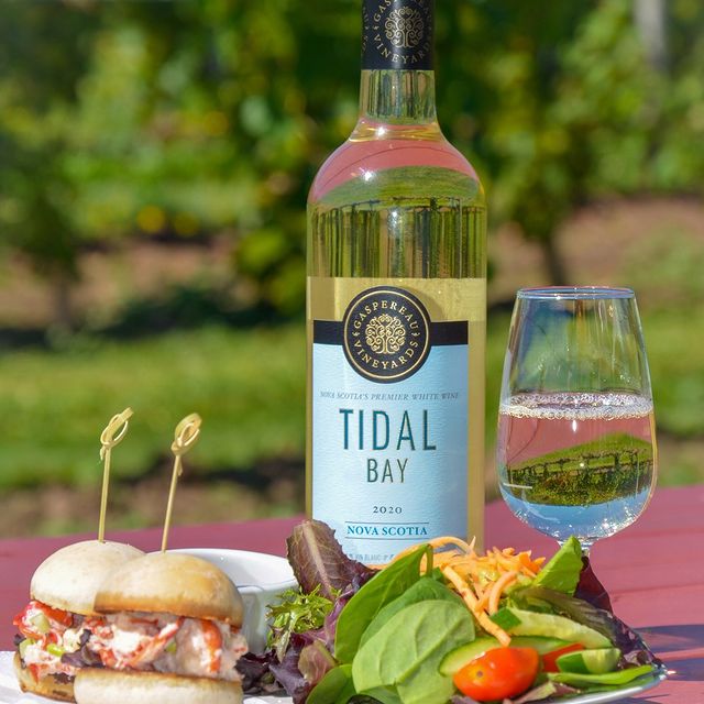 A bottle of Tidal Bay with a wine glass and food. 
