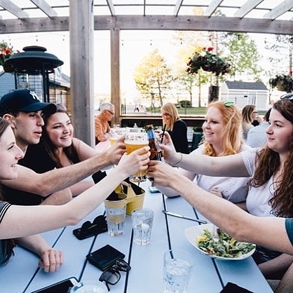 A group of people giving cheers on a patio.