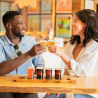 two people cheers a small flight of beer inside Tatamagouche Brewing