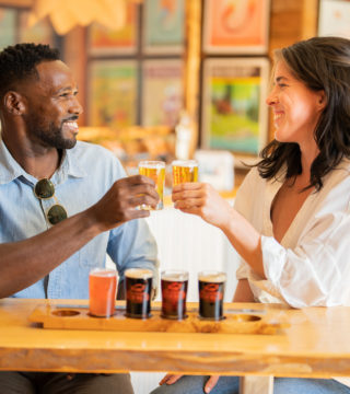 two people cheers a small flight of beer inside Tatamagouche Brewing