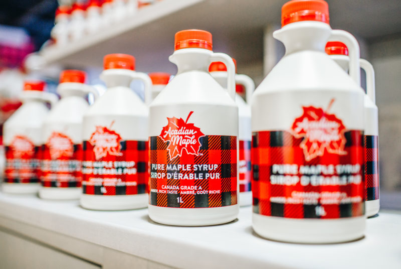several jugs of Acadian Maple Syrup line a shelf
