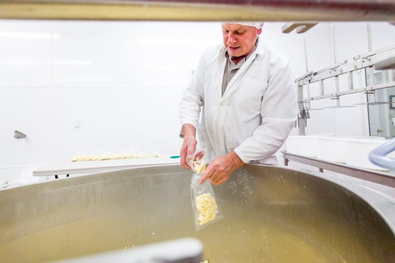 Frazer Hunter, of knoydart scoops cheese curds into a plastic bag