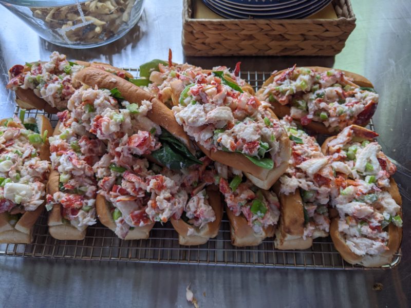 several lobster rolls sit stacked on a cooling rack