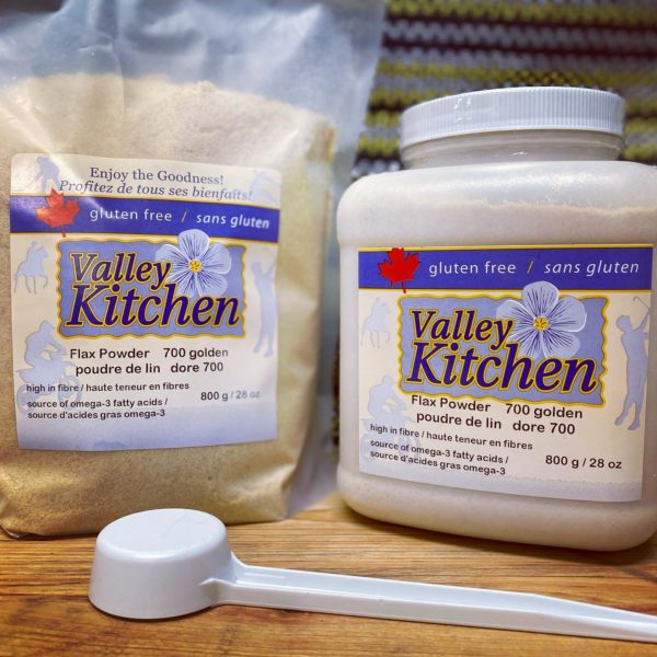 one bag and one plastic container flax powder sit on a wooden table