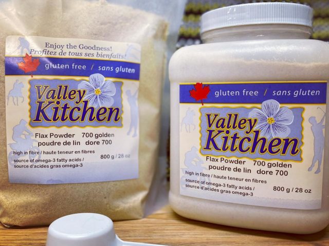 one bag and one plastic container flax powder sit on a wooden table
