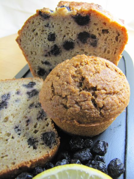 blueberry muffins. one is whole, one is cut in the middle 