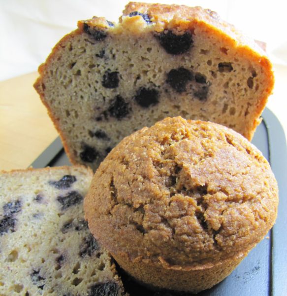 blueberry muffins. one is whole, one is cut in the middle