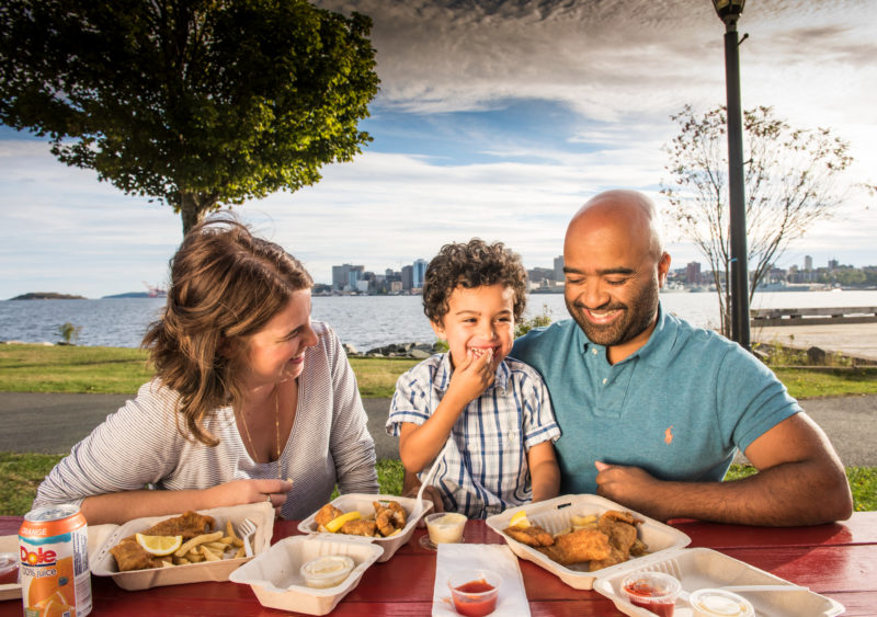A small family enjoying a meal by the waterfront