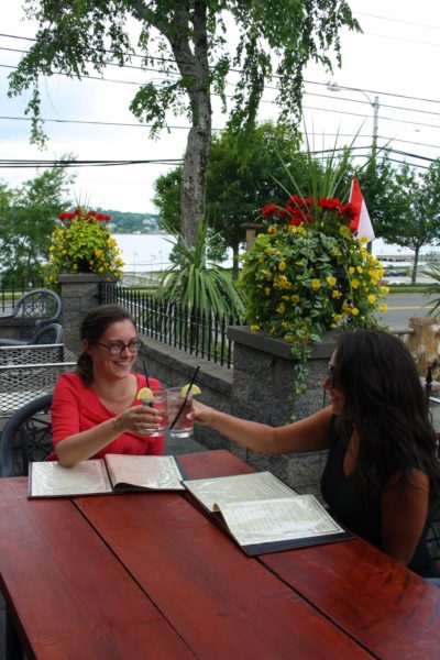 two people cheers on the patio at Governors. There are lots of plants and hanging baskets in the background