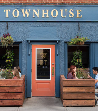 Two groups of people sit on the patio outside at the Townhouse