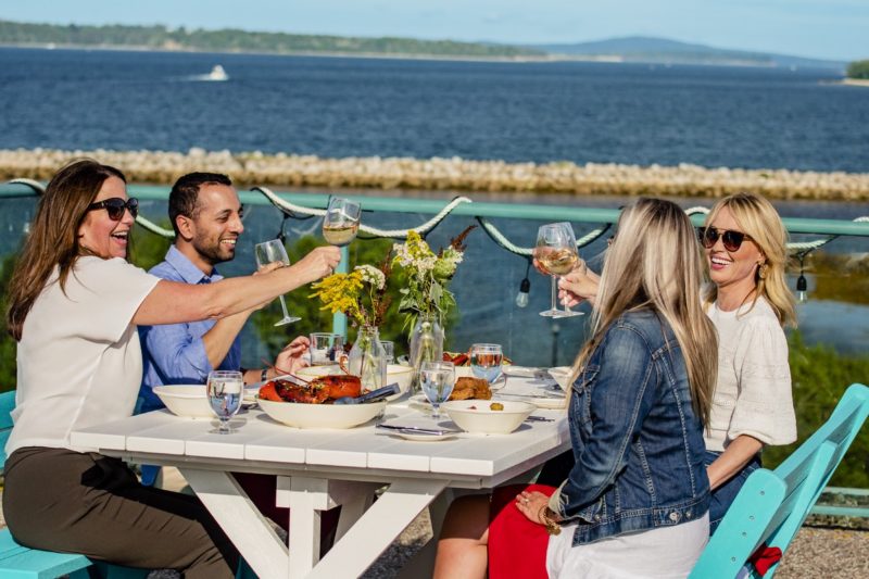 a group cheers outside on the patio at Oak Island