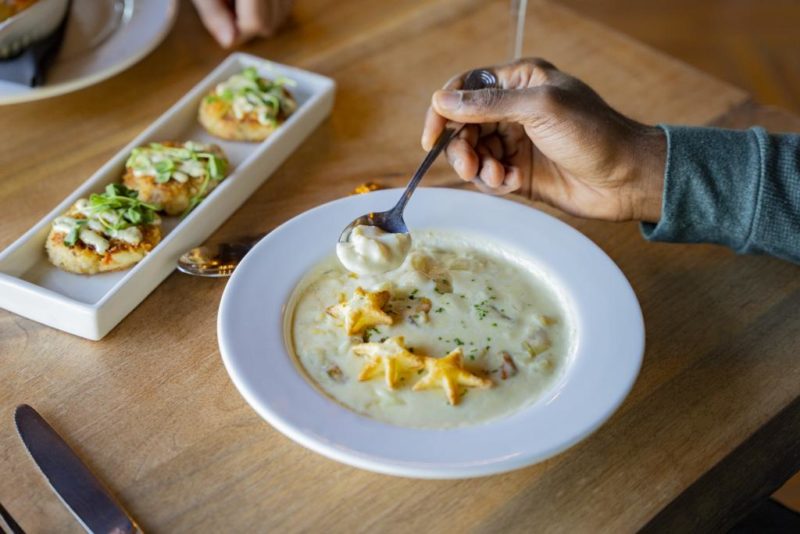 a bowl of chowder from pictou lodge as someone spoons some out