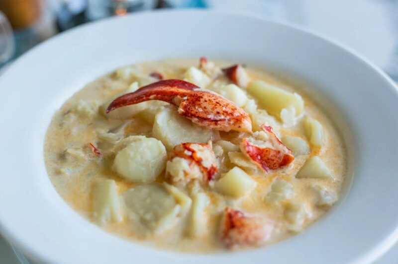 A photo of a bowl of chowder topped with lobster meat at La Cuisine Robicheau