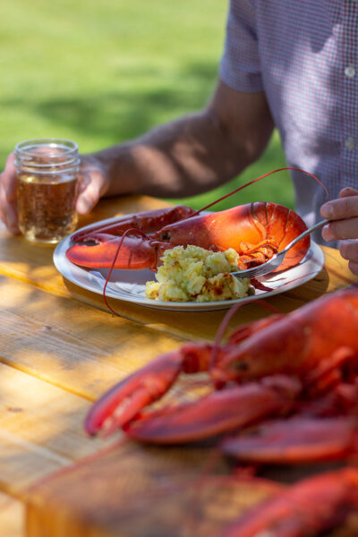 A photo of a man sitting at a table with lobster from Victoria Cooperative Fisheries Ltd. Photo credit: Shannon MacIntyre/EatWithShannon