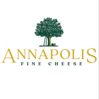 A photo of the logo for Annapolis Fine Cheese. There is a green tree with a ladder against it and a bushel under it. Under the image, it says Annapolis Fine Cheese.