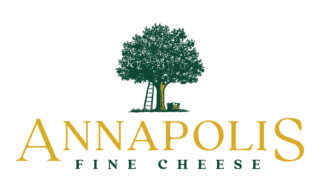 A photo of the logo for Annapolis Fine Cheese. There is a green tree with a ladder against it and a bushel under it. Under the image, it says Annapolis Fine Cheese.