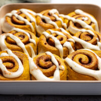 Baking dish of nine cinnamon rolls glazed