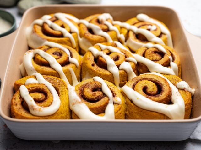 Baking dish of nine cinnamon rolls glazed